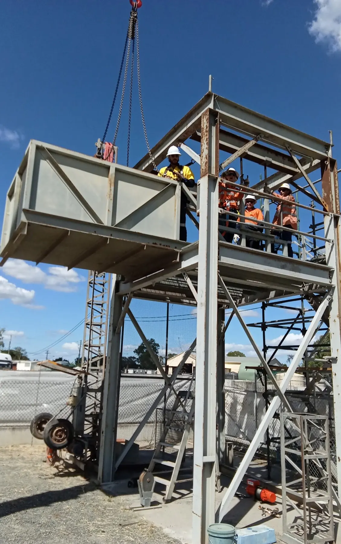 Trainees on the steel training tower guiding a box lift