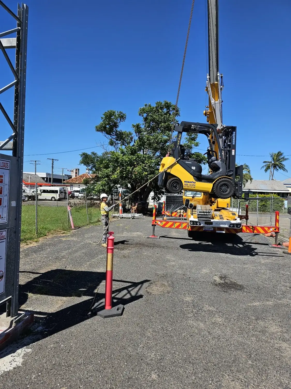 Trainees guiding a forklift being lifted by crane at the Forky Stick yard